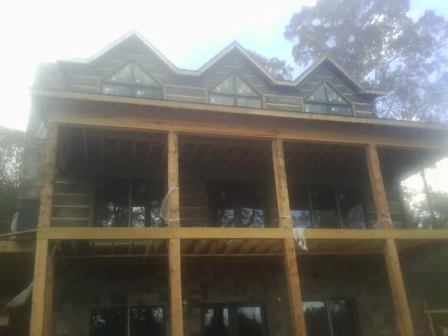 Dormers and porch framing on a large log home under construction — Roof Coating work by our crew in Hogansville