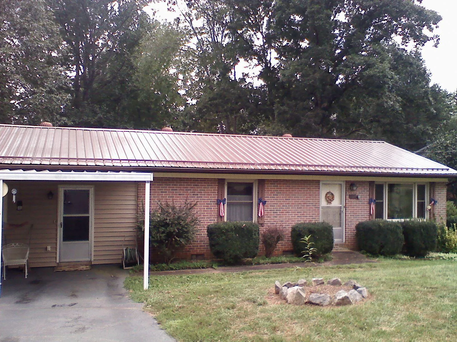 Bronze metal roof and carport on a brick ranch home — Roof Repair work by our crew in Hogansville